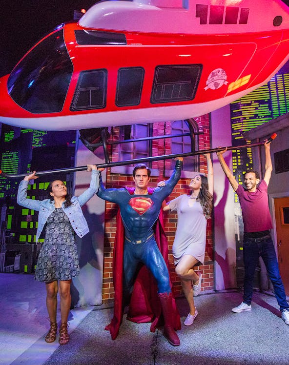 Superman figure lifting helicopter with visitors at Madame Tussauds Orlando.