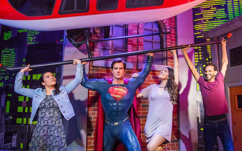 Superman figure lifting helicopter with visitors at Madame Tussauds Orlando.