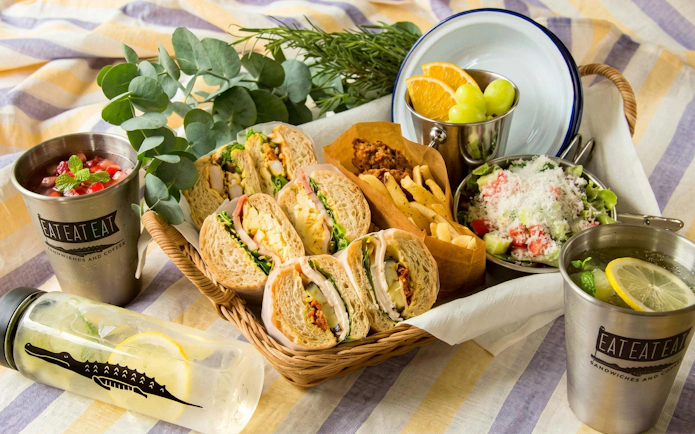 Basket of sandwiches, salad, and drinks at NIFREL Interactive Aquazoo picnic setup.