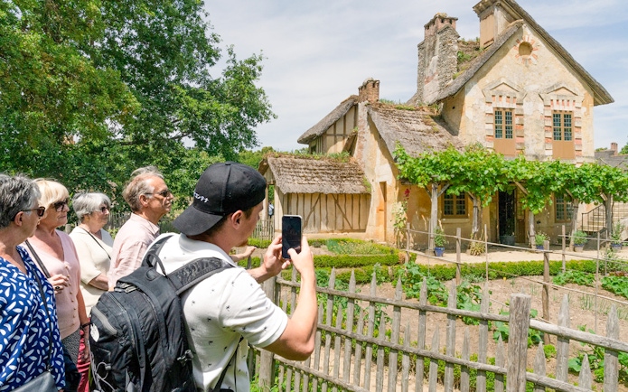 Tourists viewing a rustic cottage in the Domain of Marie-Antoinette, Versailles.
