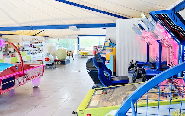 Arcade game room with racing simulators and air hockey table at Adventure Golf.