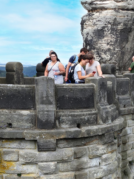 Visitors exploring Bastei Bridge during guided tour, Saxon Switzerland, Germany.