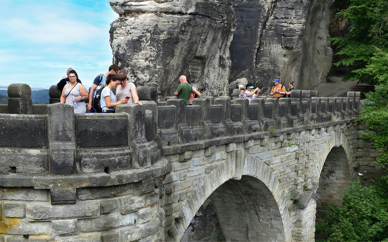 Visitors exploring Bastei Bridge during guided tour, Saxon Switzerland, Germany.