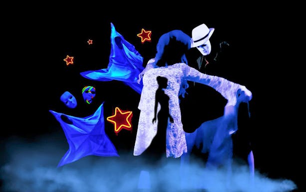 Performers in black light theatre with glowing masks and stars, Prague.