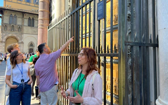 Tourists observing the Gates of Paradise at Florence's Baptistery near the Uffizi Gallery.