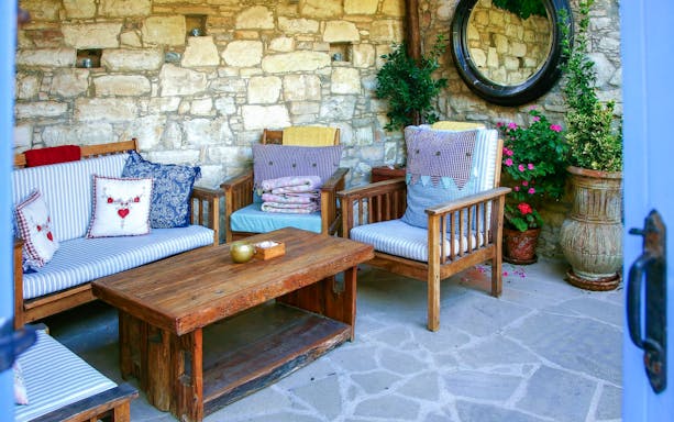 Cozy stone patio with wooden seating in Troodos Mountains, Cyprus.