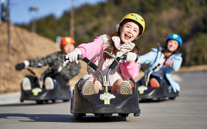 People enjoying a luge ride at Skyline Luge Busan.