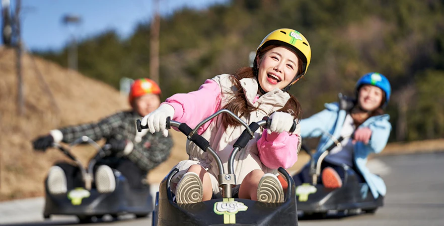 People enjoying a luge ride at Skyline Luge Busan.