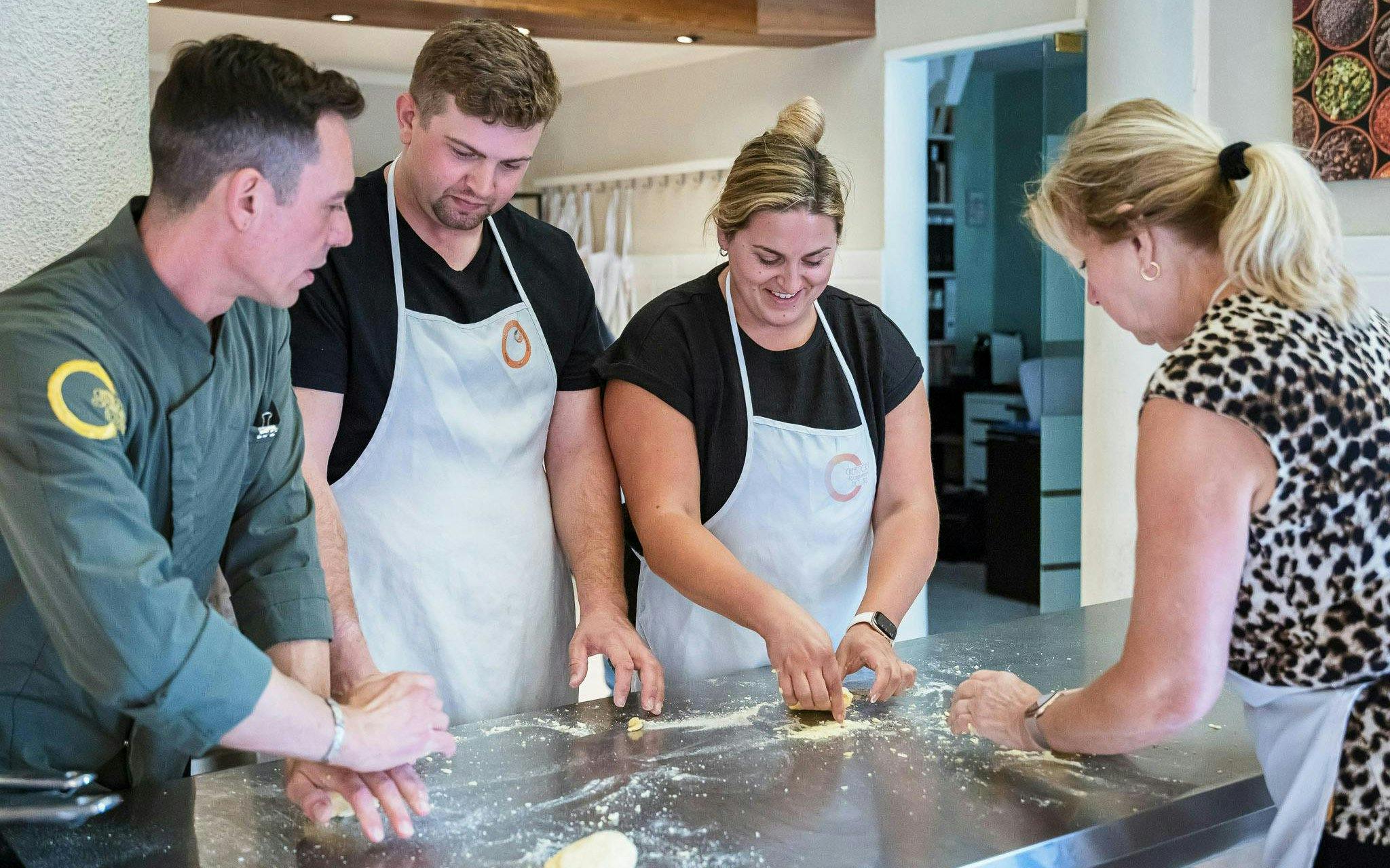 Small group learning to make pasta in a cooking class in Florence.