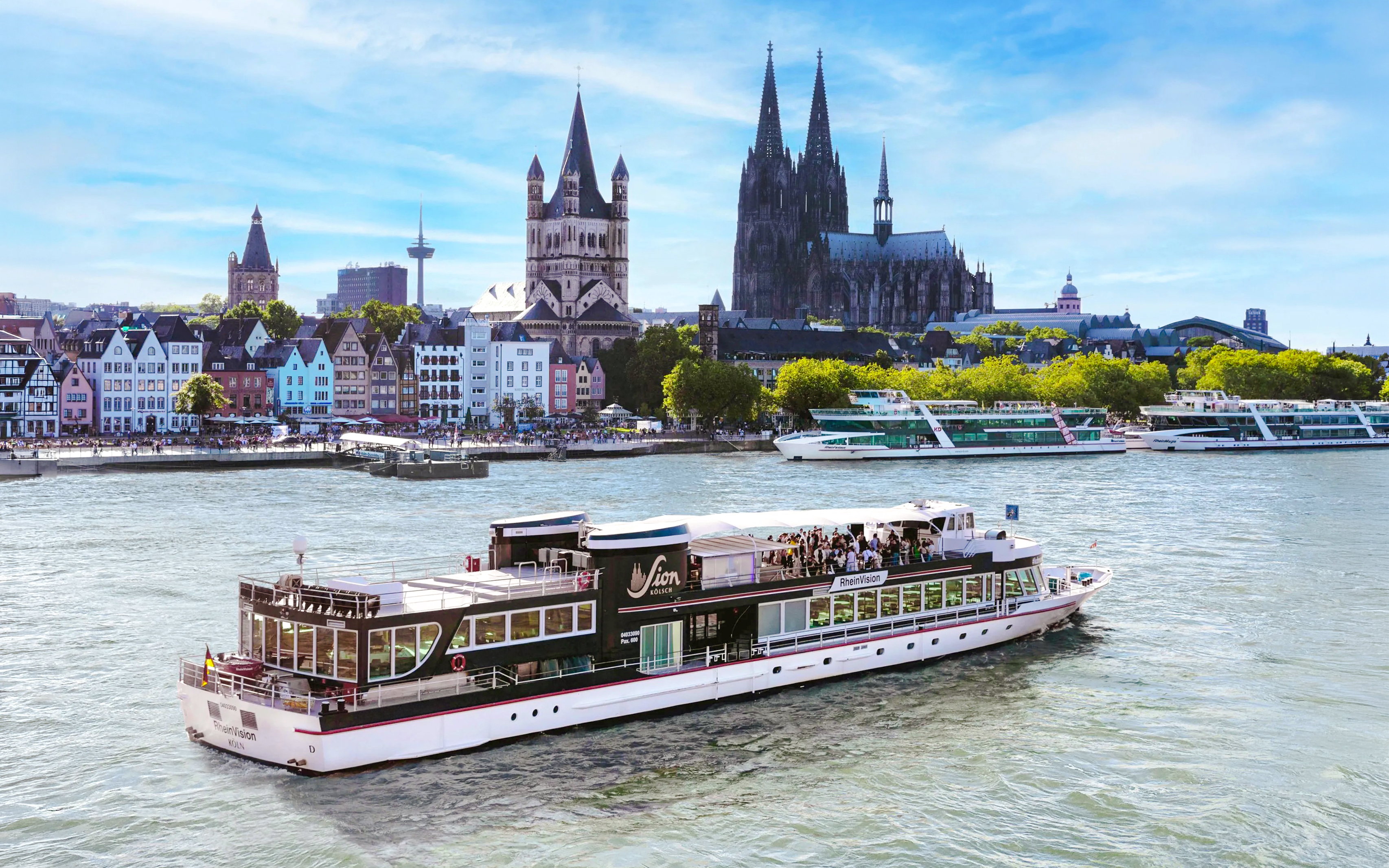 Cruise boat on the Rhine River with Cologne Cathedral in the background.