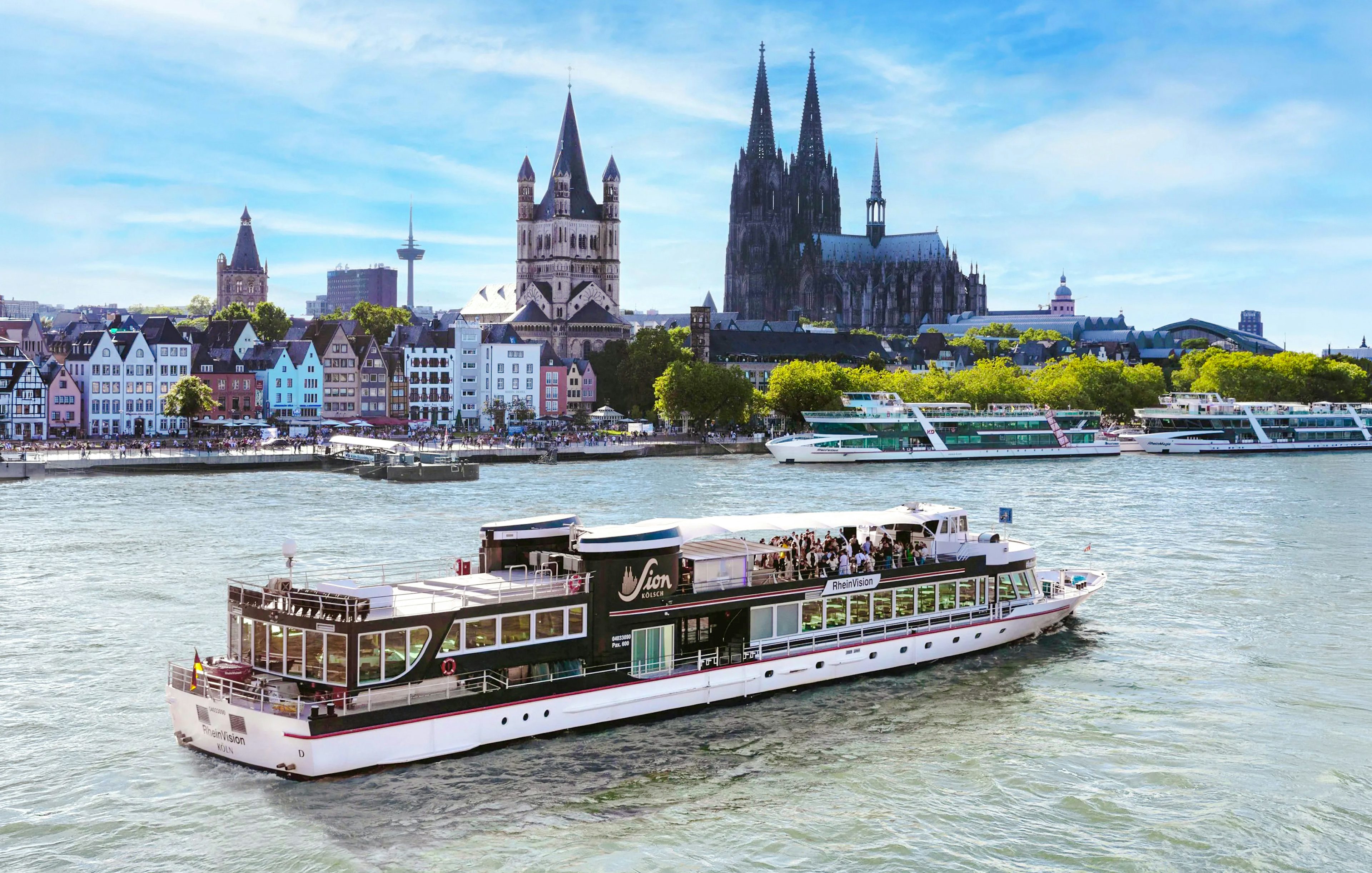 Cruise boat on the Rhine River with Cologne Cathedral in the background.