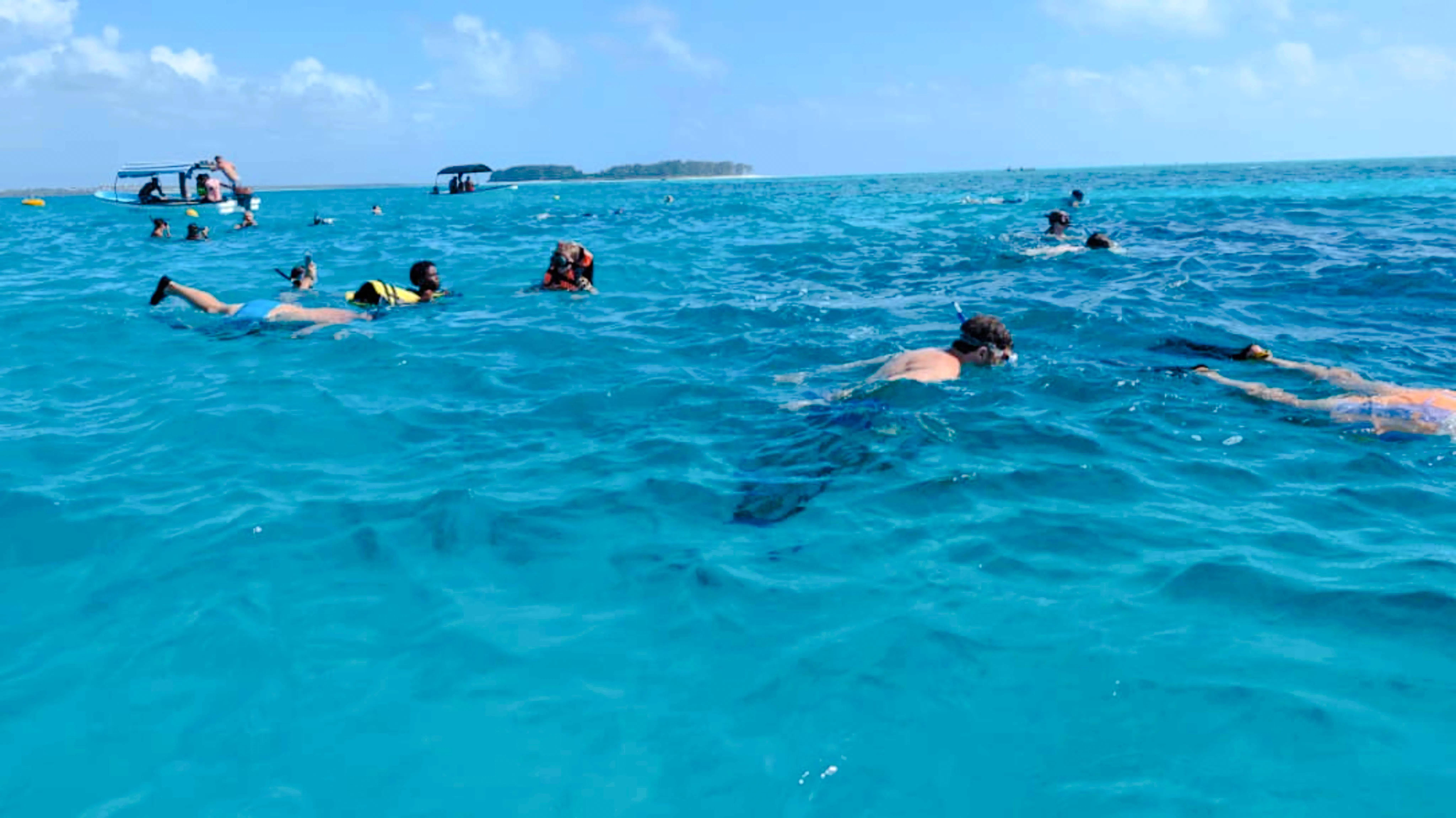 Snorkelers exploring clear waters on Mnemba snorkeling tour, Zanzibar.