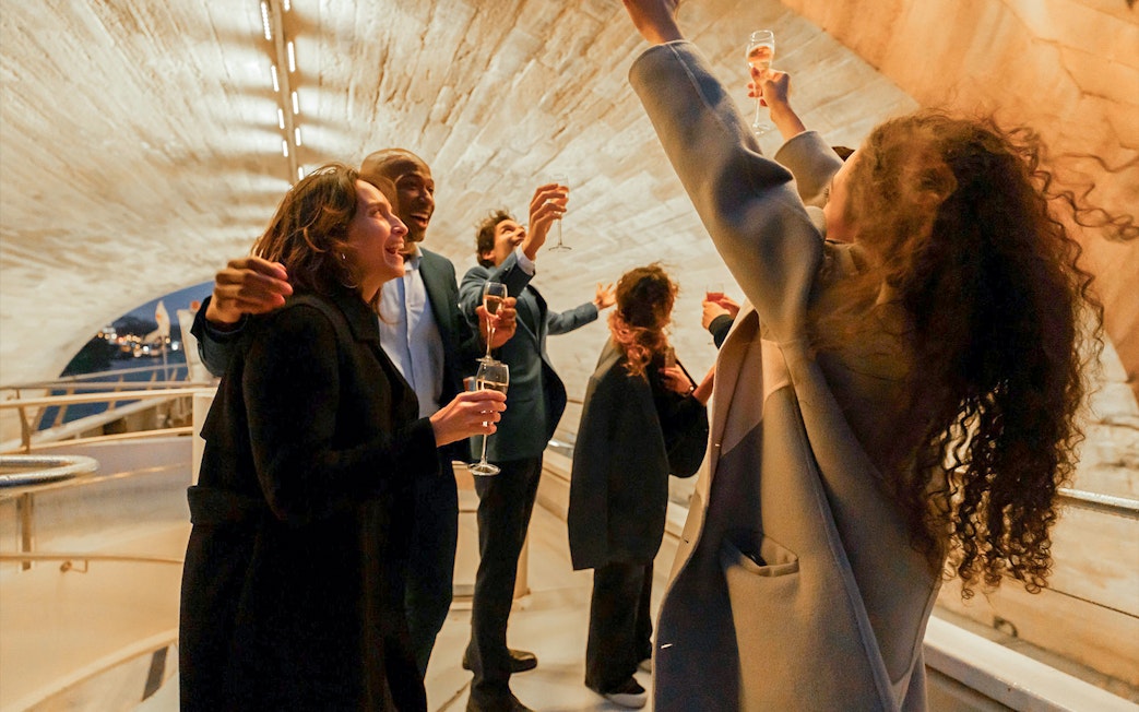 Guests toasting on a Bateaux Mouches Seine River dinner cruise in Paris.