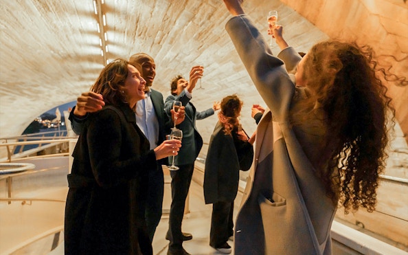 Guests toasting on a Bateaux Mouches Seine River dinner cruise in Paris.