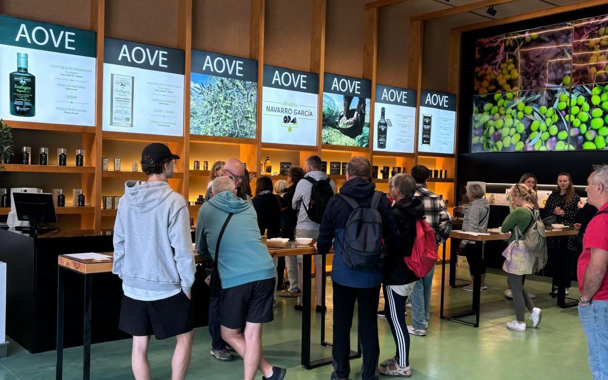Tourists sampling olive oil at Navarro García outlet in Granada during Lecrín Valley excursion.