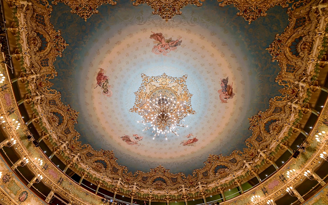 Teatro La Fenice ornate ceiling with chandelier, Venice opera house interior.