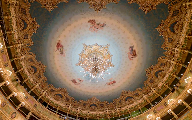 Teatro La Fenice ornate ceiling with chandelier, Venice opera house interior.