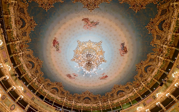 Teatro La Fenice ornate ceiling with chandelier, Venice opera house interior.