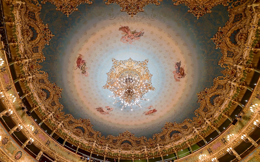 Teatro La Fenice ornate ceiling with chandelier, Venice opera house interior.