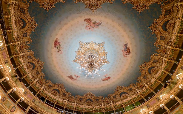 Teatro La Fenice ornate ceiling with chandelier, Venice opera house interior.