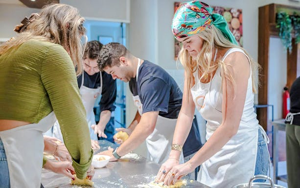 Participants kneading dough in a small group cooking class in Florence.