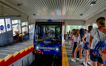 Cable car at Gubałówka station with tourists boarding in Zakopane, Poland.