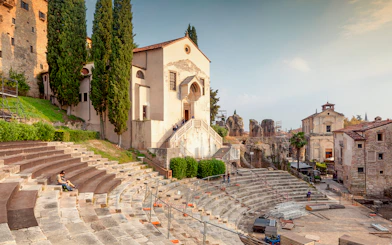 Teatro Romano Verona with ancient stone seating and nearby historic buildings.