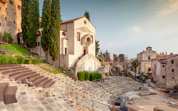 Teatro Romano Verona with ancient stone seating and nearby historic buildings.