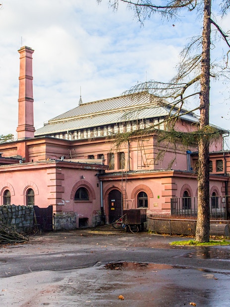 Historic building at Wroclaw Zoo, Poland, surrounded by trees and a wet pathway.