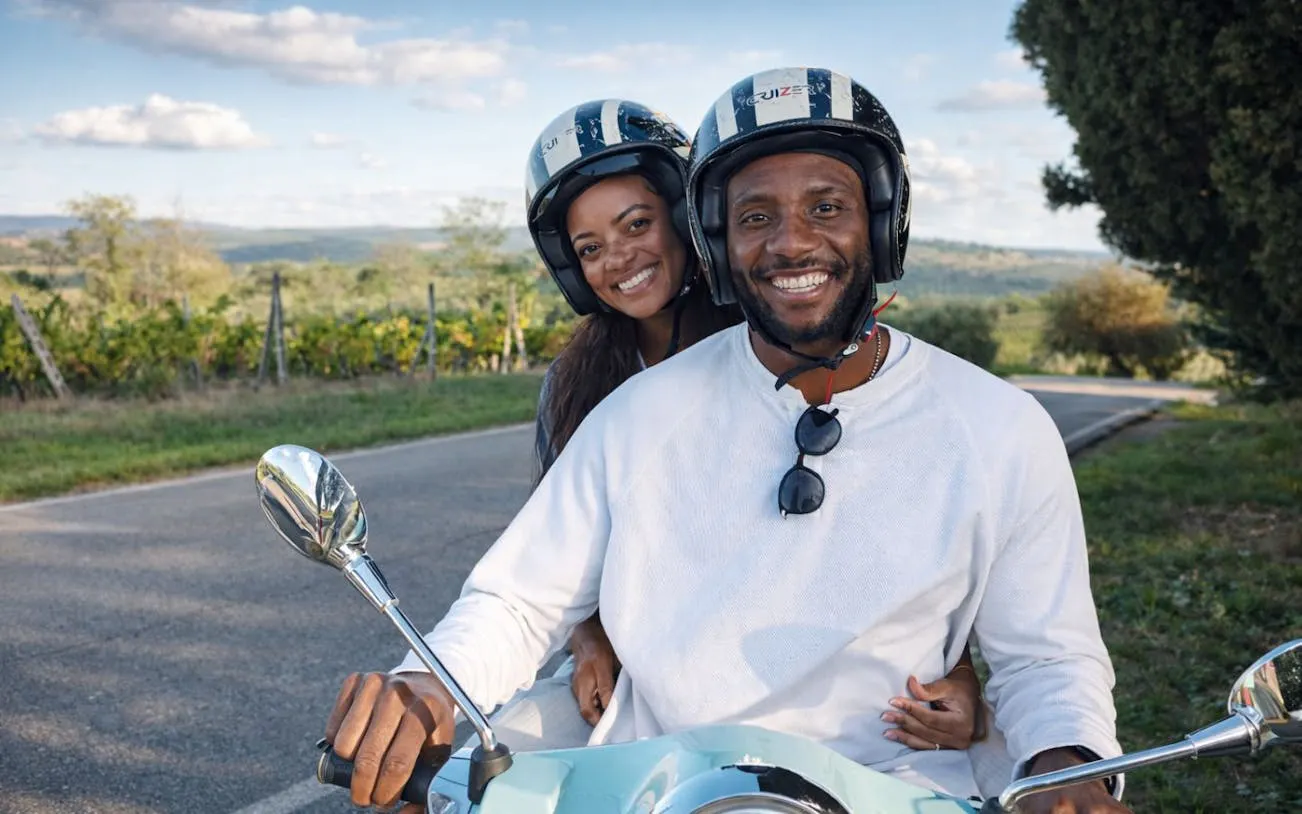 Couple riding a Vespa through Chianti countryside on a private tour.