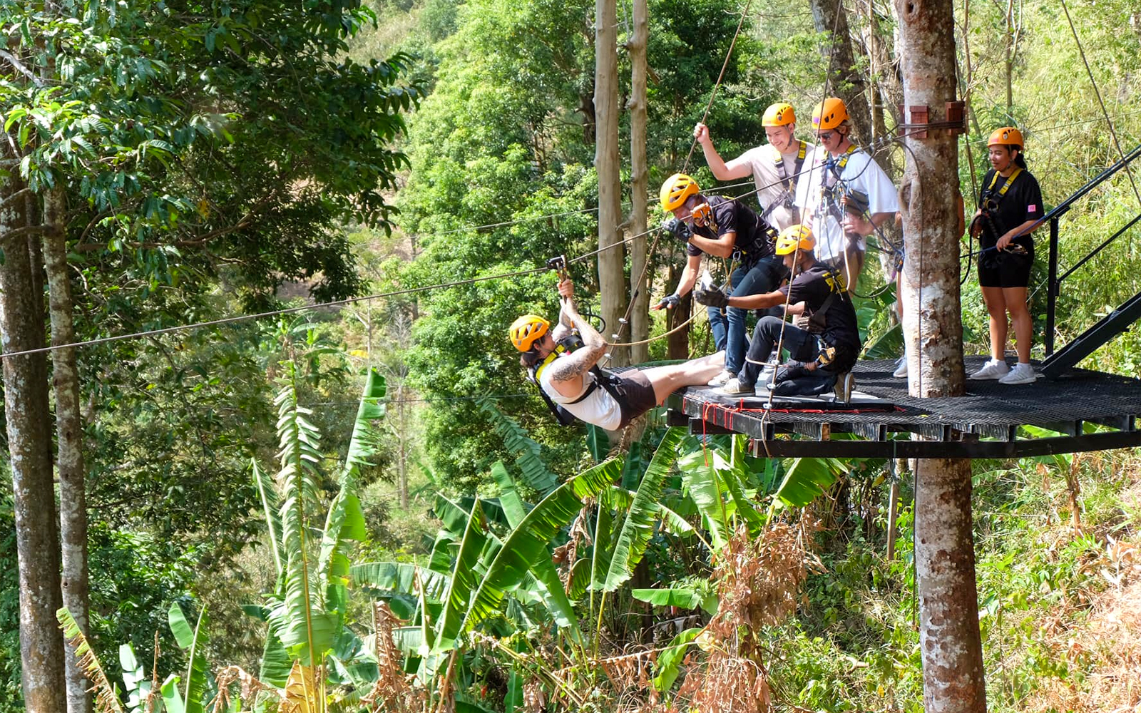 Participants ziplining through lush forest in Phuket.