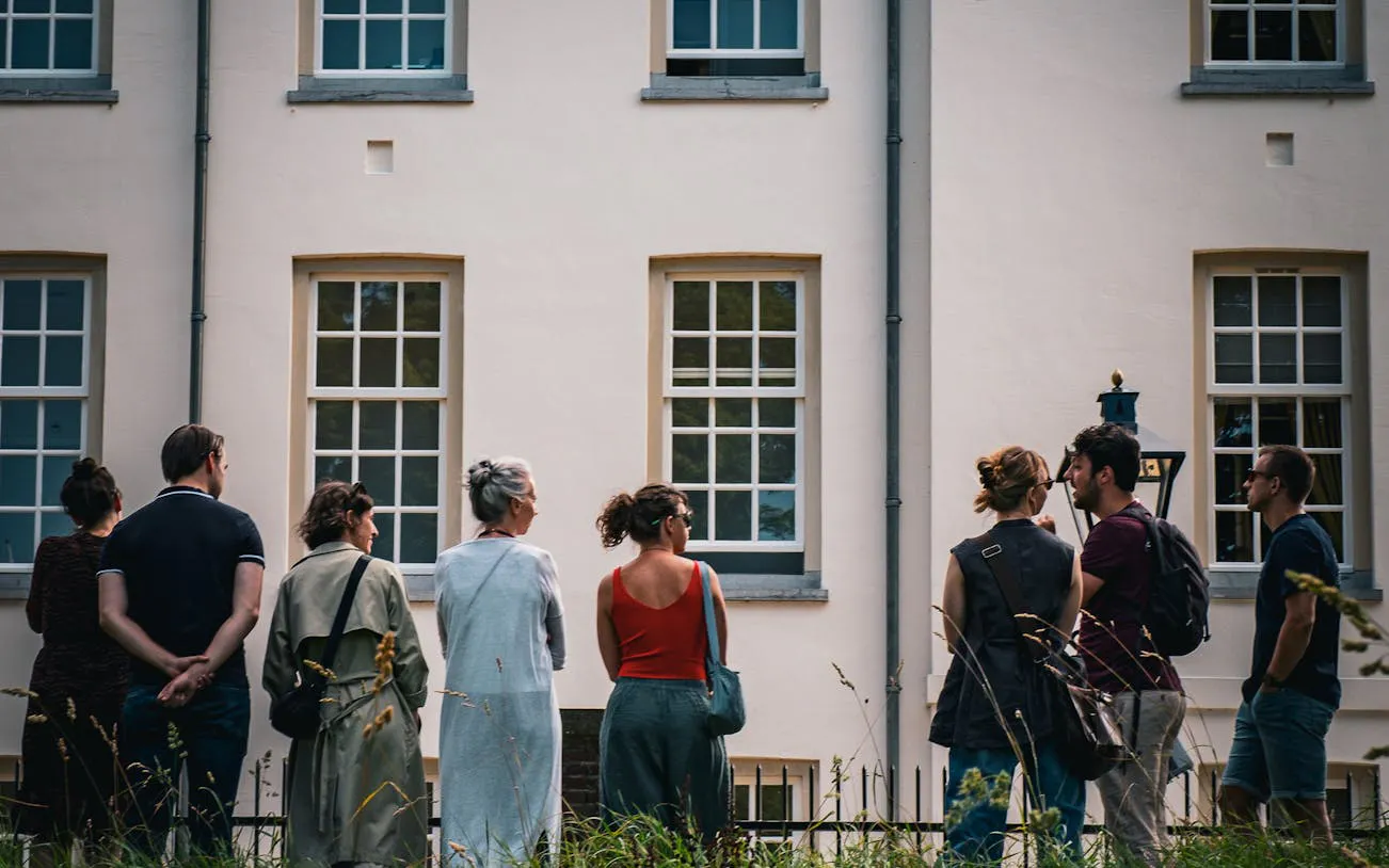 Group of tourists on a walking tour in Utrecht, standing in front of a historic building.