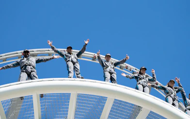 Visitors on Optus Stadium Vertigo tour standing on roof with safety gear, Perth.