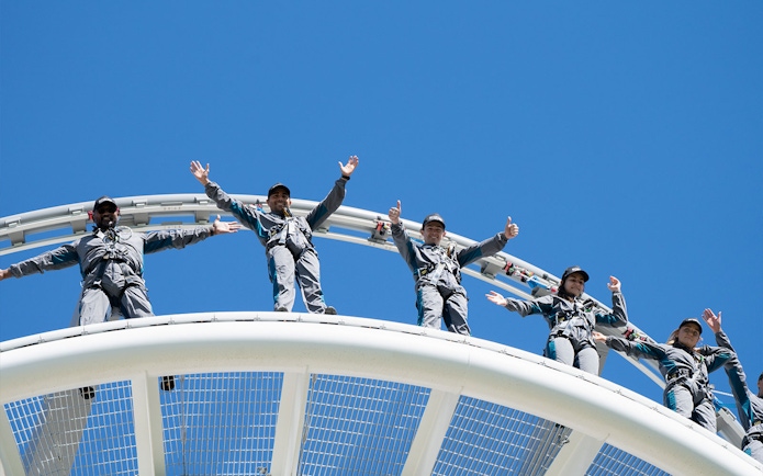 Visitors on Optus Stadium Vertigo tour standing on roof with safety gear, Perth.