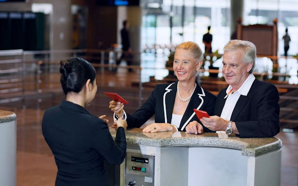 Couple using VIP fast-track service at Suvarnabhumi Airport immigration counter.