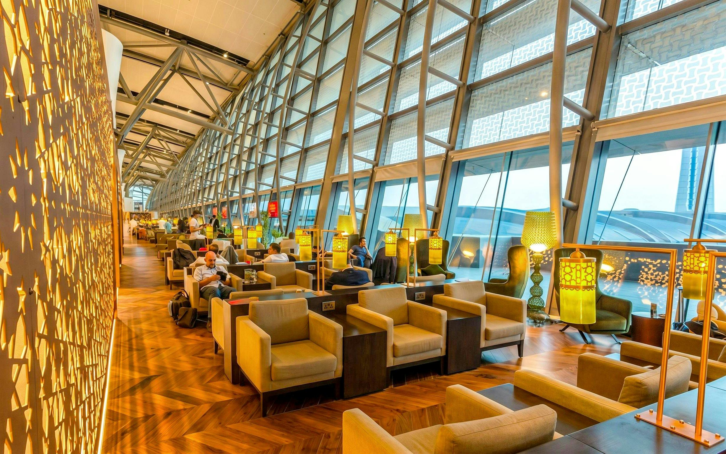 Primeclass Lounge seating area at Muscat International Airport departures, featuring modern decor and large windows.