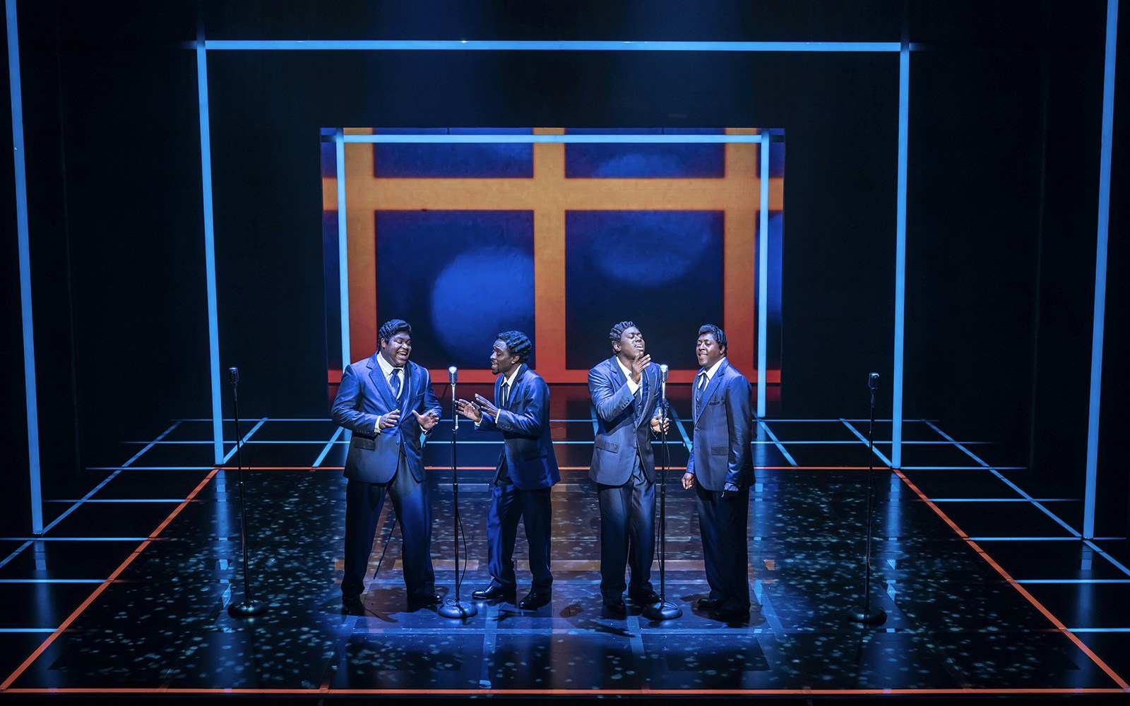 Four performers singing on stage in "The Drifters Girl" musical.
