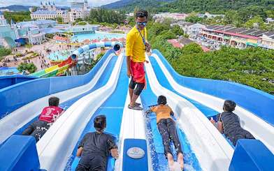 Visitors enjoying water slides at Splash Out Langkawi Water Theme Park, Malaysia.