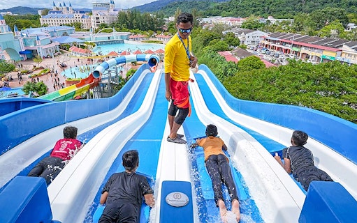 Visitors enjoying water slides at Splash Out Langkawi Water Theme Park, Malaysia.