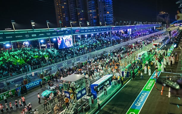 Crowds gather at the Formula 1 Jeddah Grand Prix 2026 starting grid under bright lights.