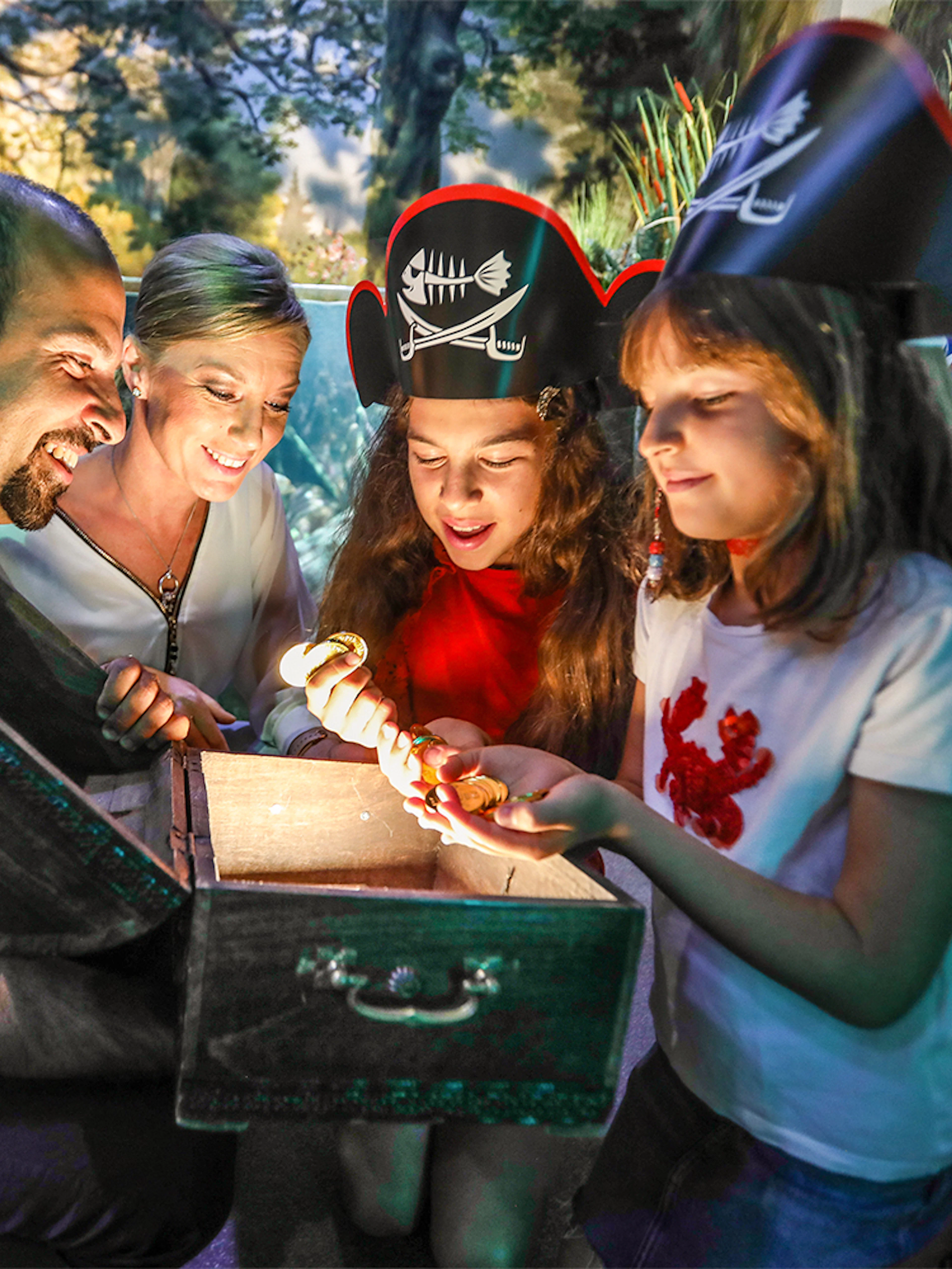 Family discovering treasure chest at Sea Life Konstanz aquarium.