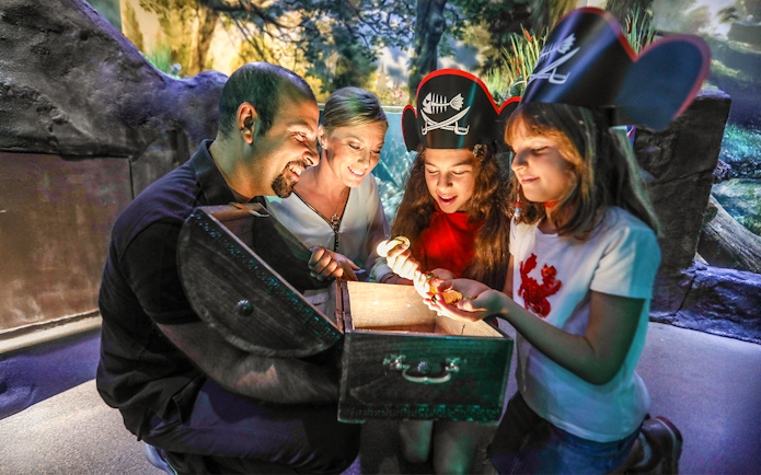 Family discovering treasure chest at Sea Life Konstanz aquarium.