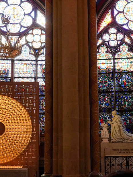 Stained glass windows and statue inside Notre Dame Cathedral, Paris.