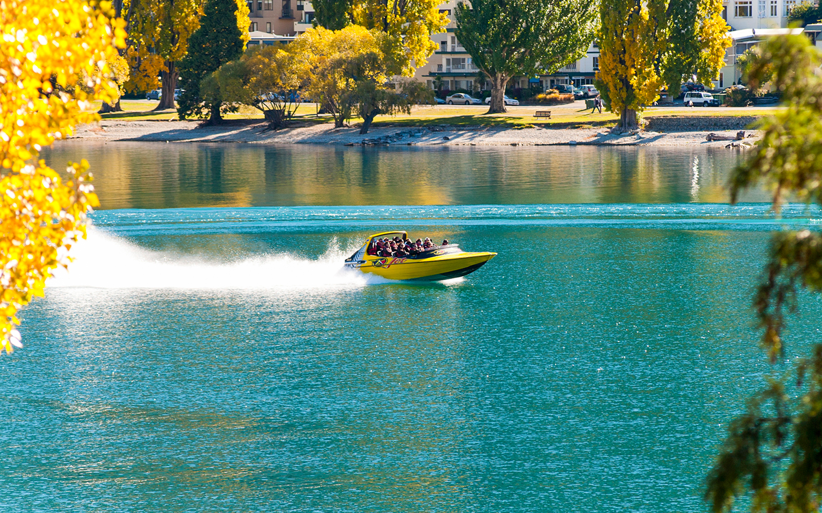 Jet boat speeding through Shotover River canyon in Queenstown, New Zealand.