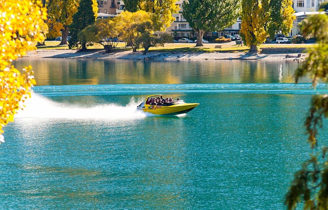 Jet boat speeding through Shotover River canyon in Queenstown, New Zealand.