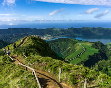 Hikers on a trail overlooking Sete Cidades crater lakes in Azores, Portugal.