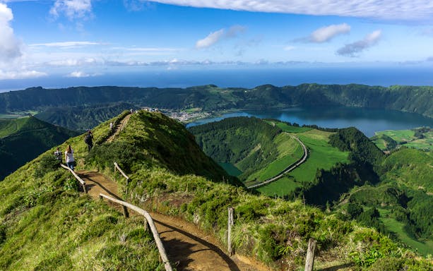 Hikers on a trail overlooking Sete Cidades crater lakes in Azores, Portugal.