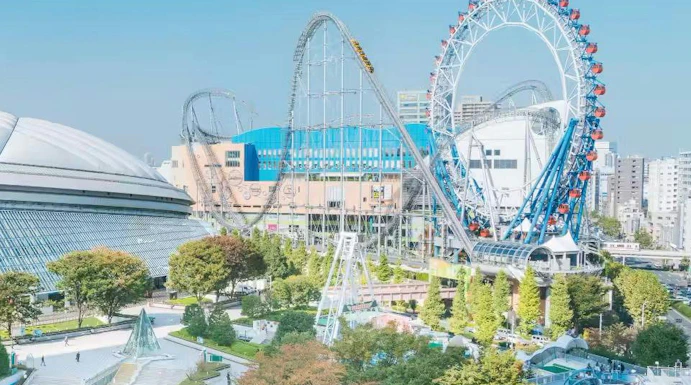 Tokyo Dome and amusement park with roller coaster and Ferris wheel in Tokyo, Japan.