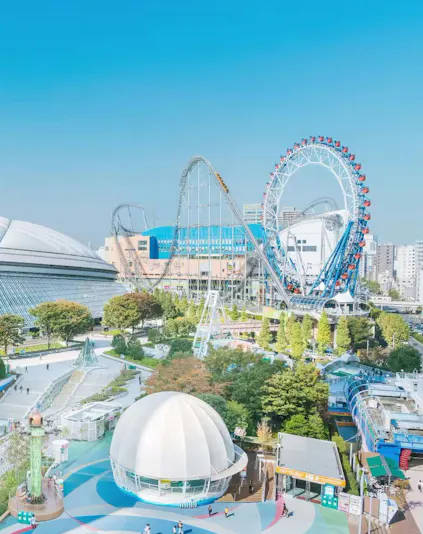 Tokyo Dome and amusement park with roller coaster and Ferris wheel in Tokyo, Japan.