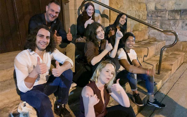 Group of people sitting on steps during Melbourne's past crimes walking tour.